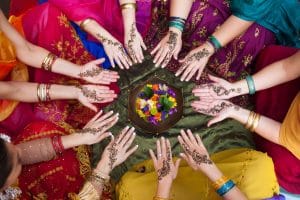 Indian women reaching hands in a circle 