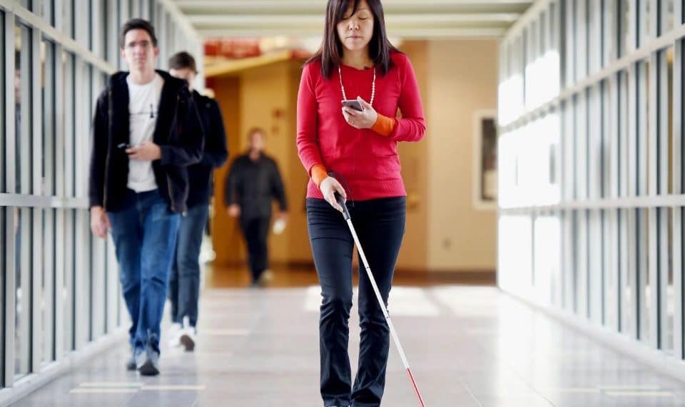 A blind woman navigates with a stick